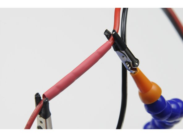 Once cooled, slide the length of heat shrink back over the joined wires.