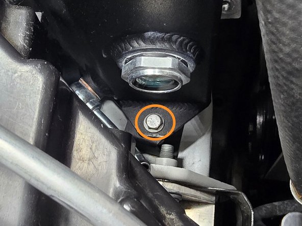 Thread the provided M6x12mm bolt through the mounting hole on the front side of the coolant tank into the 27WON mounting bracket as shown