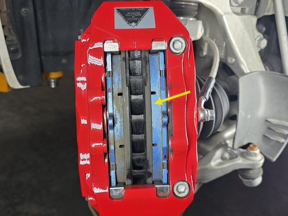 Install the new brake pad into the caliper as shown