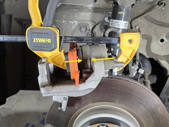 Using a C-clamp as shown or a caliper compressing tool, compress the caliper piston enough for the new pads to fit over the OE rotor