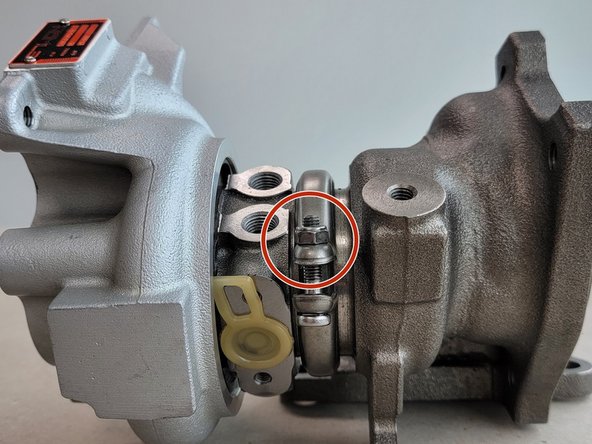 Using a 10mm socket remove the nut (red circle) holding the V-band clamp