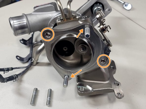 Install four (4) provided studs in turbine housing by hand, as shown