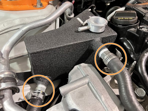 Put the 27WON coolant tank in place and reinstall the coolant hoses over the two barbs and secure with provided clamps or OE clamps where possible