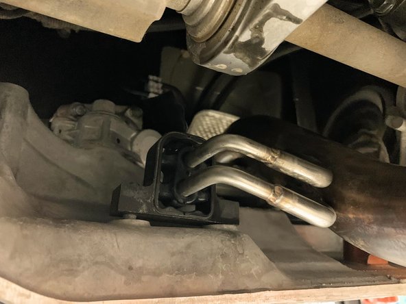 Locate the OEM front pipe hanger. Directly under this hanger will be two bolts mounting the hanger to the chassis