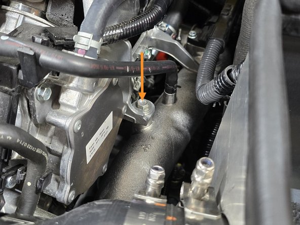 Using a 12mm socket, a long extension, and a 3/8&quot; drive ratchet, remove the bolt securing the cold pipe to the engine bracket