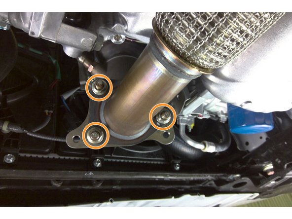 Using a 3/8&quot; drive ratchet and a 14mm socket, reinstall all three (3) nuts securing the downpipe studs Torque to 40 ft-lbs. 