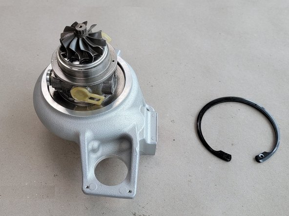 Use snap ring pliers to compress and lift the snap ring out of the groove in the compressor cover