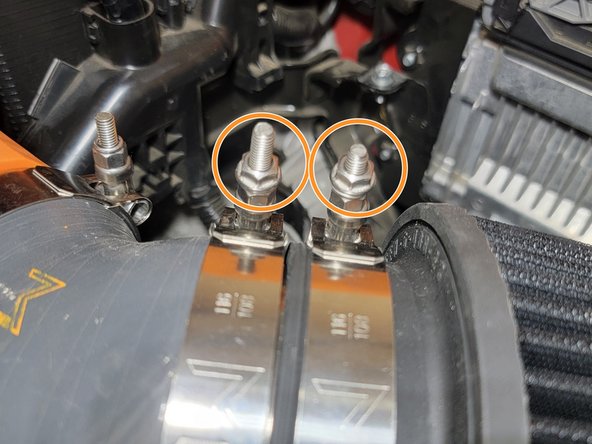 Remove both M6 nuts as shown. There are washers under the nuts. Those remain in place