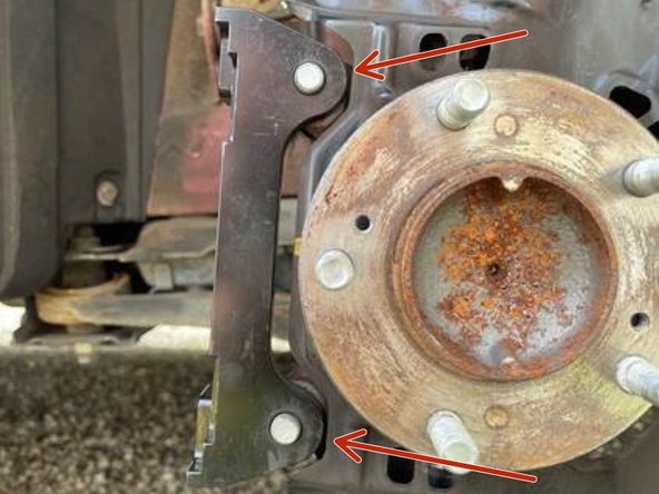 Orient the caliper brackets to the knuckle as shown