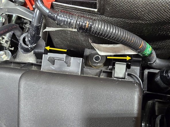 Using your fingers or a pair of needle nose pliers pinch the two battery cable clips and push them out of the airbox bracket