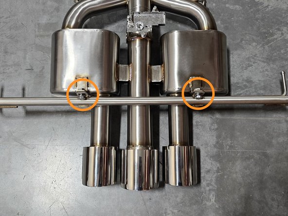 Using the shorter 20mm provided hardware loosely attach the hanger bar to the axle back section of the exhaust as shown