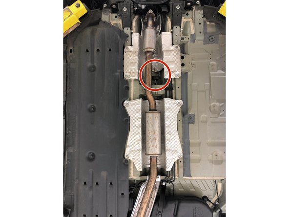 Locate the dual rod rubber hanger in the exhaust mid section