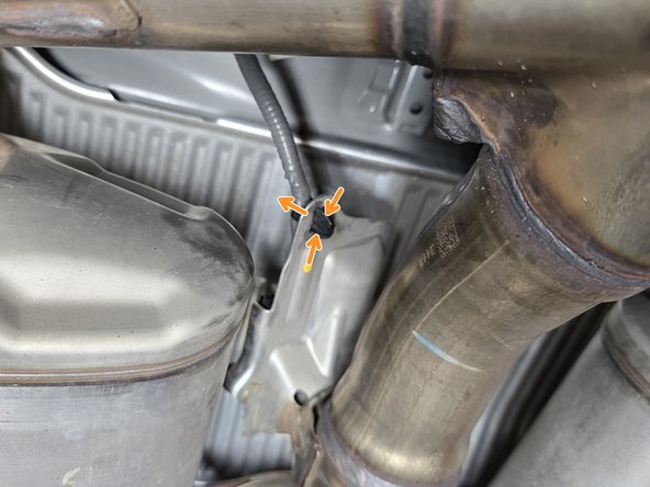 Using needle nose pliers squeeze the plastic clip as shown and push through to free the wire from the metal bracket