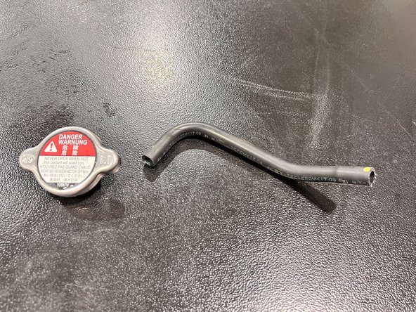 Using a slight twist and pulling motion   to remove OEM overflow  hose by pulling hose to the side