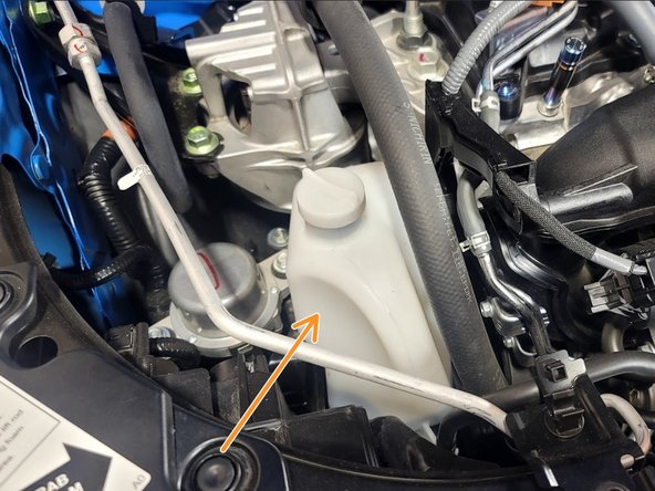 Pull up on reservoir to free from bracket and relocate as shown