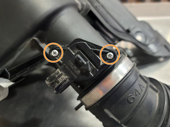 Using a small Phillips screwdriver, remove both screws securing MAF sensor to OE Intake