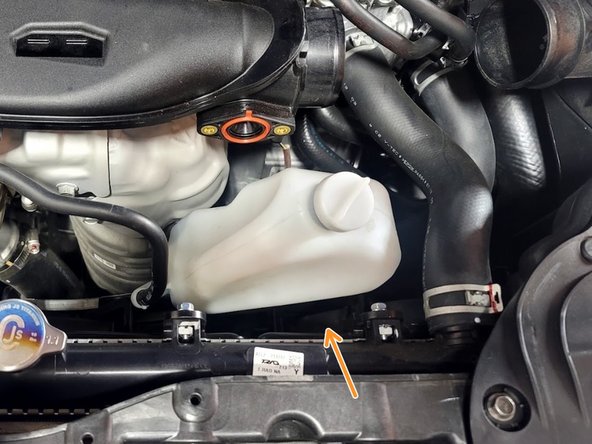 Pull up on reservoir to free from bracket and relocate as shown