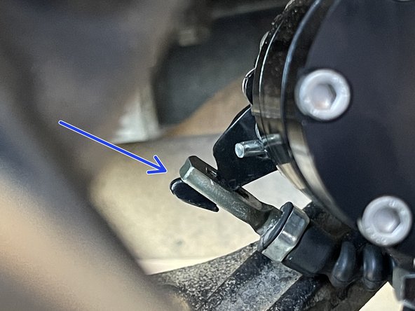 Hook the cable around the parking brake mechanism as shown