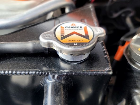Wipe clean OEM radiator cap and dry