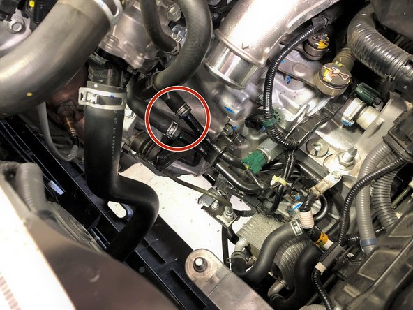 From above the vehicle locate the two spring clamps on the coolant lines that run below the cold side boost tube