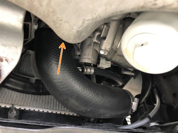 Loosen the clamp that connects the OEM hot side boost tube to the turbocharger using a 10mm socket and ratchet