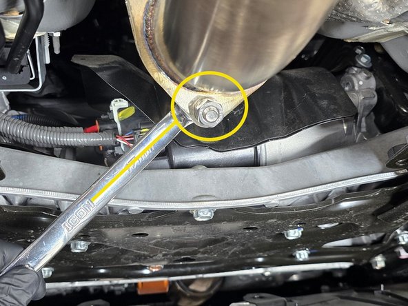 With the chassis brace removed, and a bent end wrench you can easily get a wrench on the back side of the exhaust hardware as shown