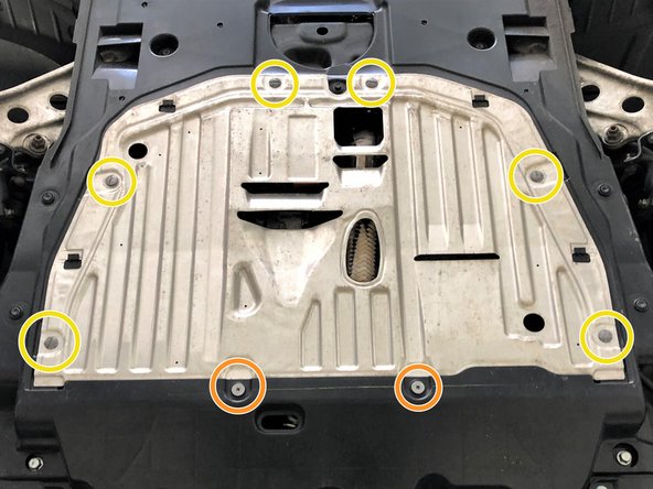 The front edge of the metal will fit over the top of the rear edge of the plastic section of the undertray