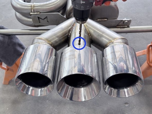 The exhaust has been flipped and you will start by working on the bottom side i.e. the side of the exhaust that faces down when on the vehicle. Note the orientation of the 'W" logo