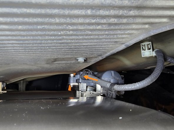 Reaching above the hanging axle back section, plug the valve motor back in with your hand as shown