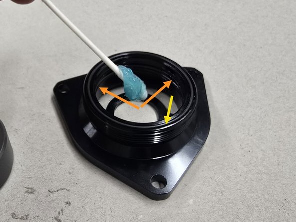 With the components all clean, generously apply the provided grease as shown: