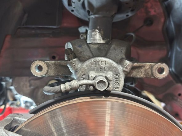 Remove the caliper from the rotor as shown