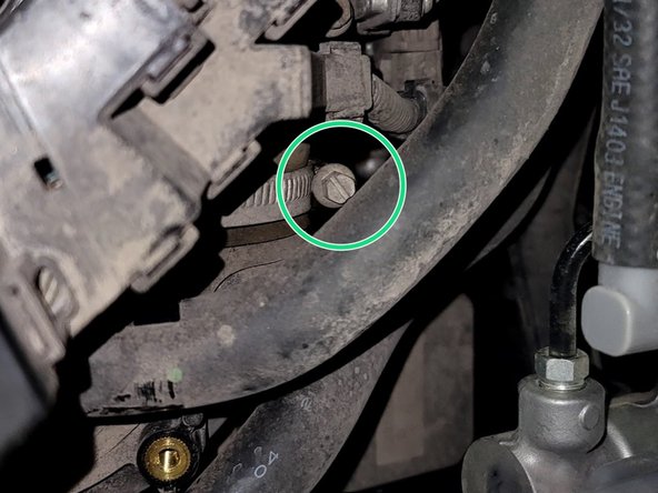 Loosen hose clamp at throttle body with 10mm socket and ratchet