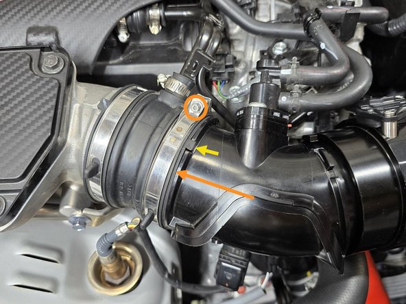 While pressing the EVAP elbow into the TIP coupler, use a 5.5mm socket and 3/8&quot; ratchet or a small Phillips screwdriver to tighten the OE clamp as shown