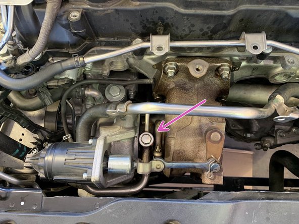 On the top, remove the 14mm bolt holding the hard oil feed line as shown