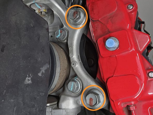 Use a 19mm socket and breaker bar to remove the two caliper bolts circled in orange
