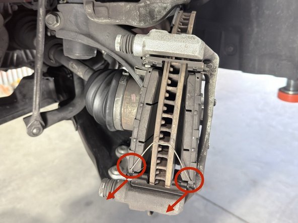 Remove brake pad retaining clip by pulling out as shown. Set aside, it's reused