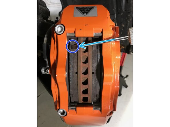 Using a 5mm Allen wrench, remove the caliper bridge bolt