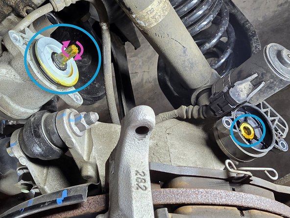 Use a 5mm Allen head socket and a 3/8" drive ratchet to remove the two bolts securing the parking brake motor as shown