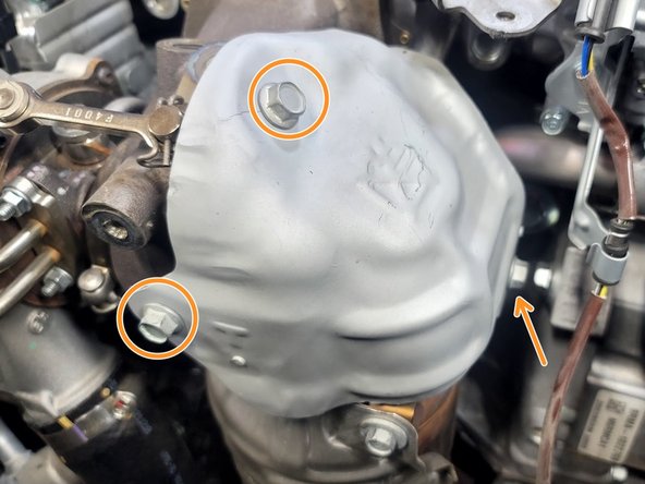 Use a 12mm socket and ratchet to remove the three (3) x  bolts securing the upper heat shield to the factory downpipe