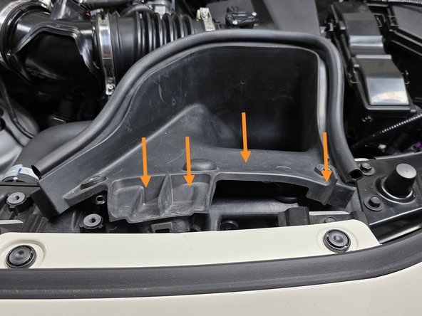 Use your hand to press the intake inlet back into its slots on the radiator shroud