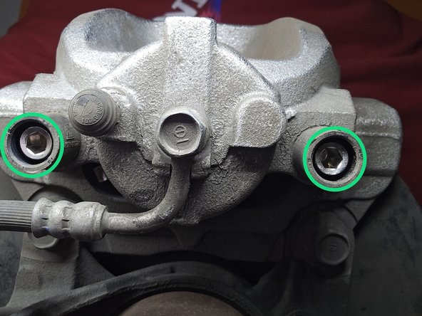 Before proceeding, verify the brake pad alignment tabs are sitting in the caliper and caliper bracket as shown