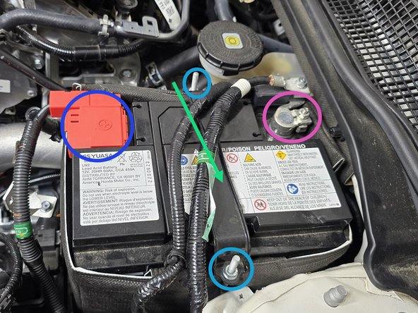 Place the battery tie down over the battery in the orientation shown, with the shorter hook towards the drivers side of the vehicle