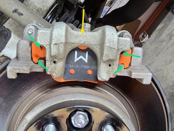 Install your OE caliper over the brake pads as shown