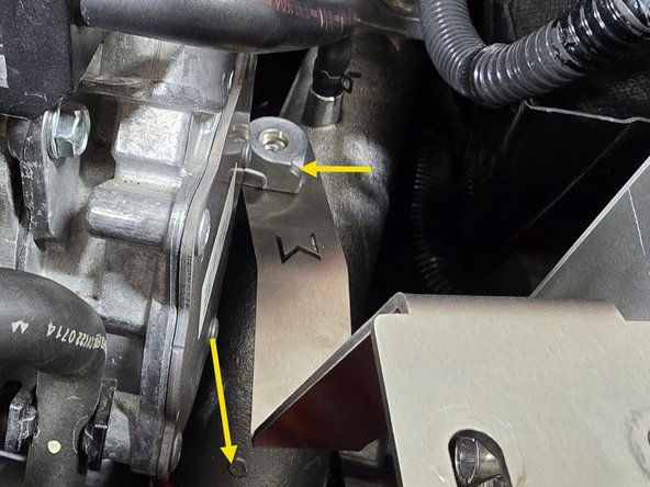 While pressing down on the cold pipe, slide the filter bracket in between the cold pipe and the engine bracket