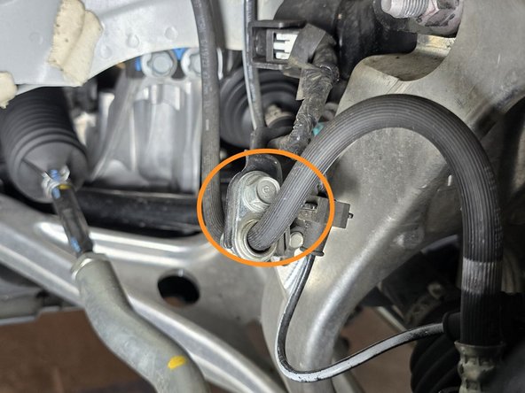 Use a 12mm socket and a 3/8" drive ratchet to remove the bolt circled in orange