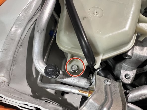 Use 10mm socket, ratchet, and extension to remove (2) 10mm bolts securing the coolant tank to its chassis brackets
