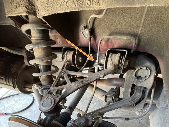 Use a 10mm line wrench to loosen the threaded brake line connection (shown with orange box)