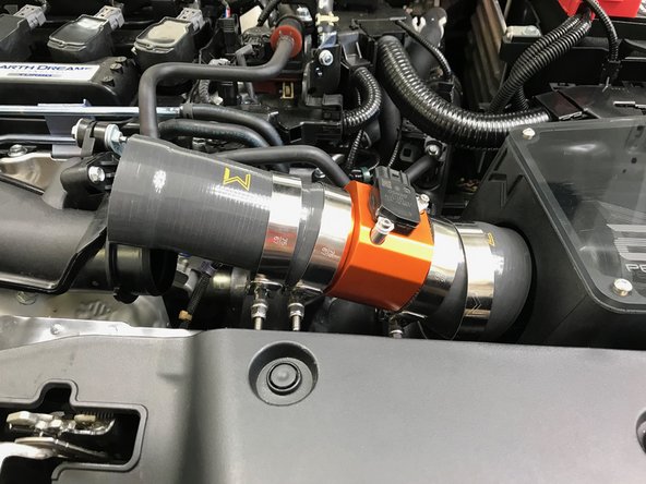 Angle the MAF &amp; Silicone assembly into the engine bay and onto the airbox