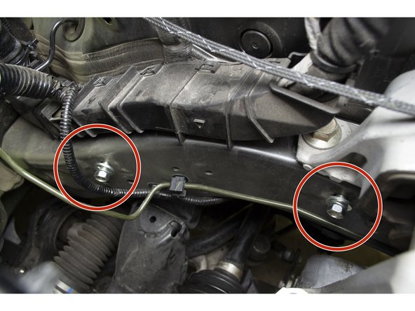 Partially start the two lower 12mm bolts by hand. The battery bracket will rest between the washer and the engine bay