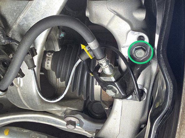 Moving to directly behind the rotor use your fingers to pull the ABS sensor wire free from the brake line bracket. You may need to wiggle it back and forth to get it free